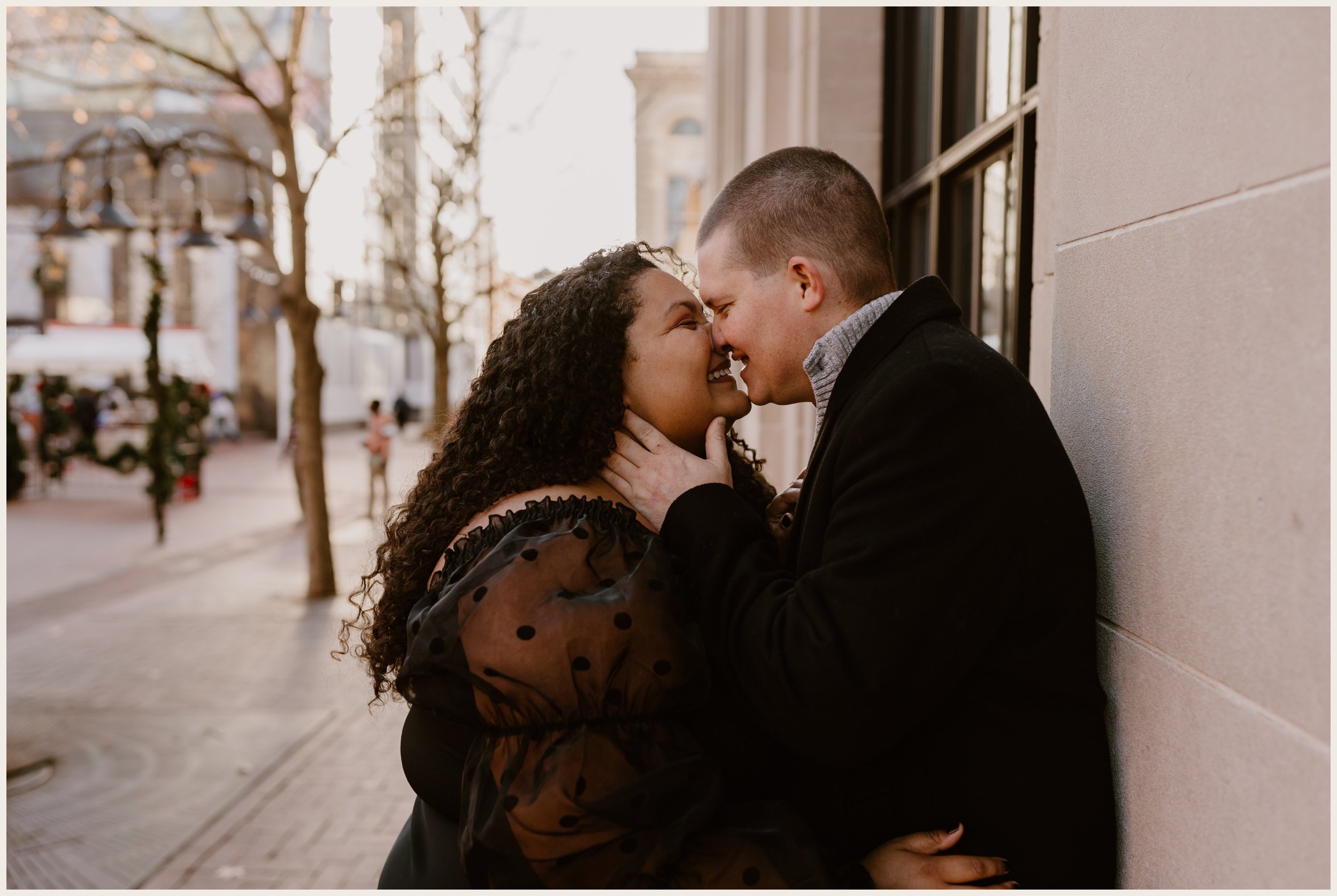  Couple kissing against a building in downtown  Charlottesville, Virginia 