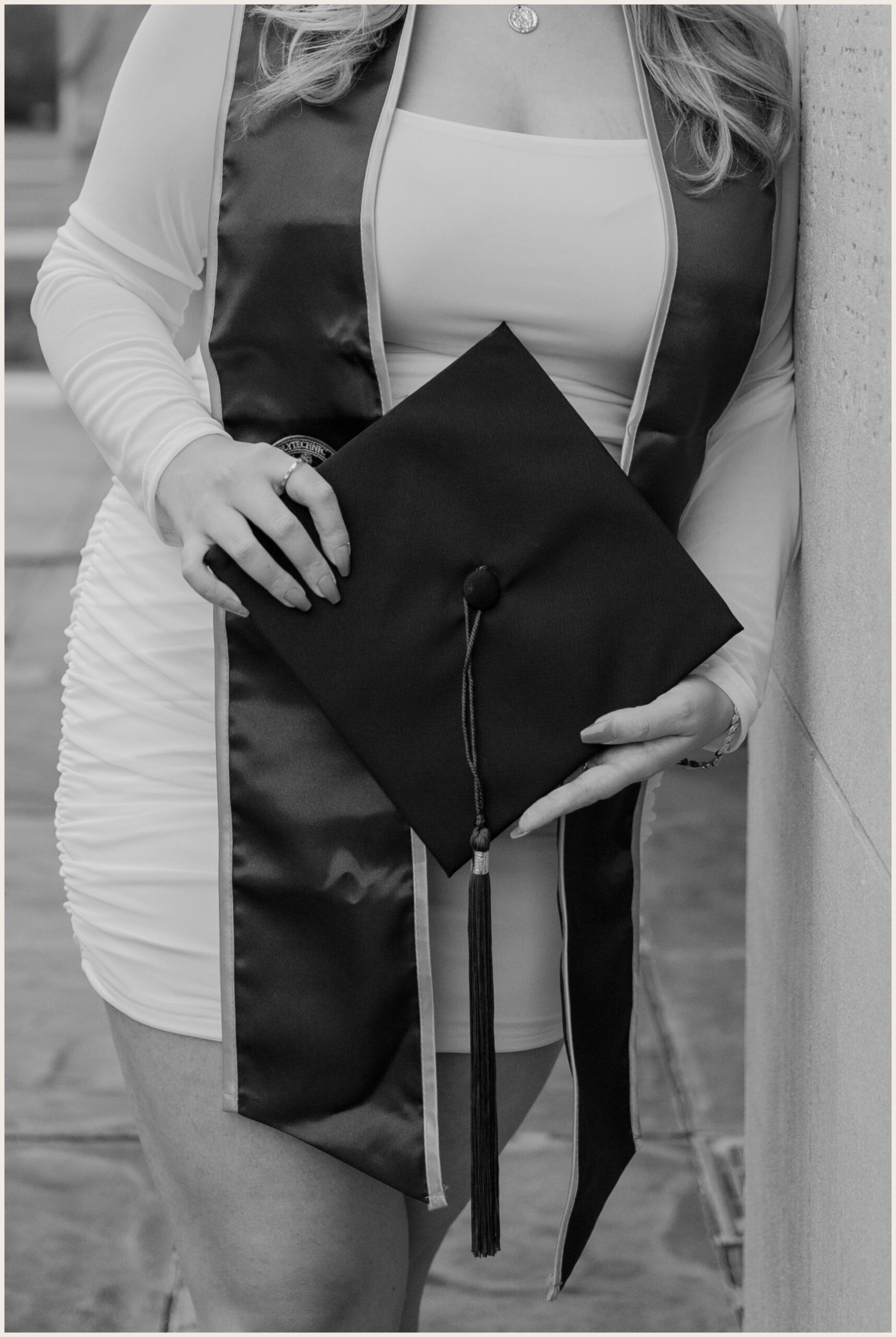 black and white close up of a graduation cap in a woman's hand