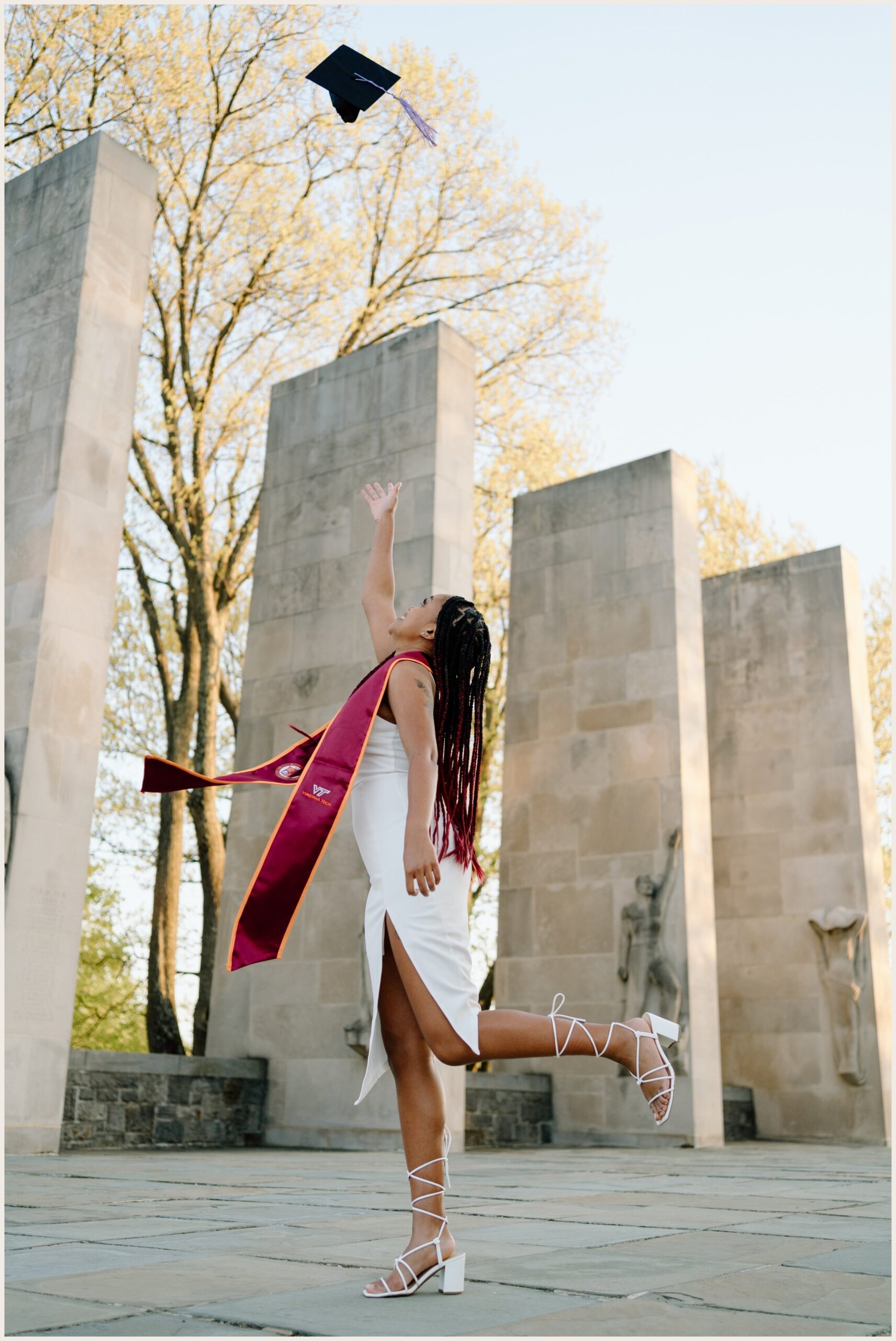 Virginia Tech graduation portrait of a woman tossing her cap